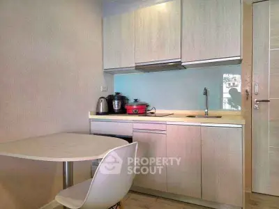 Modern compact kitchen with sleek cabinetry and dining area