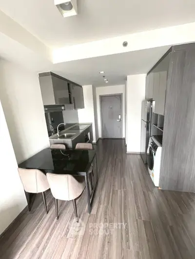 Modern kitchen with sleek cabinetry and dining area in contemporary apartment
