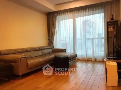 Spacious living room with large windows and modern furniture in urban apartment.