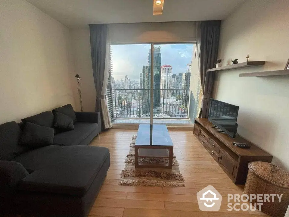 Spacious living room with modern furnishings, hardwood floors, and a stunning city skyline view through the large window, perfect for urban living.