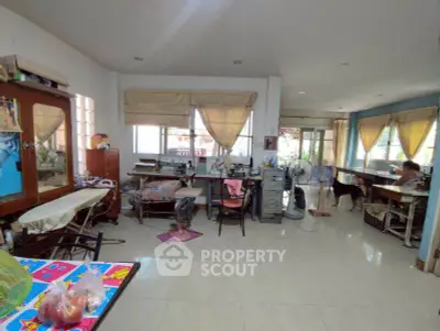 Spacious multi-purpose room with sewing stations and natural light