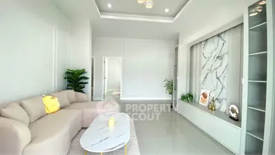 Spacious modern living room with elegant marble accent wall and cozy beige sofa.