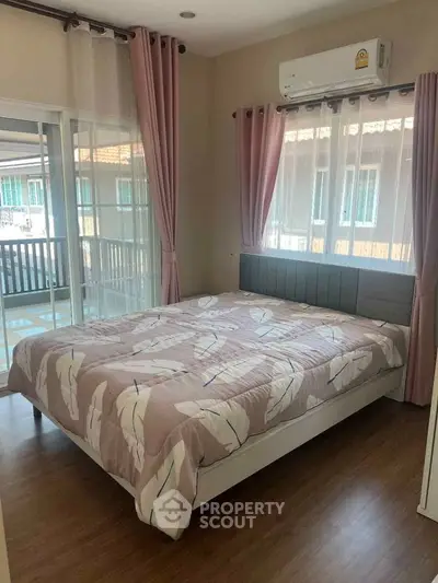 Cozy bedroom with large windows and pink curtains, featuring a comfortable bed and air conditioning.