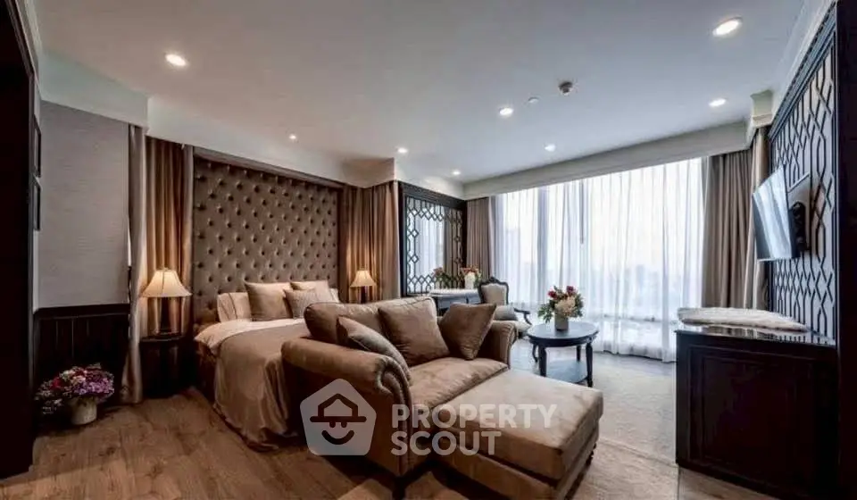 Luxurious bedroom with elegant decor and large windows offering natural light.