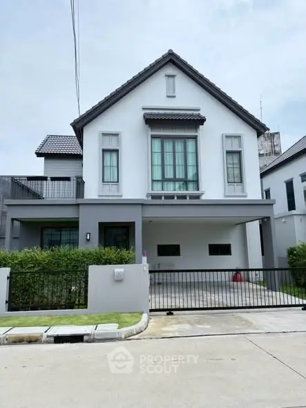 Charming modern two-story house with a spacious driveway and lush greenery in a serene neighborhood.