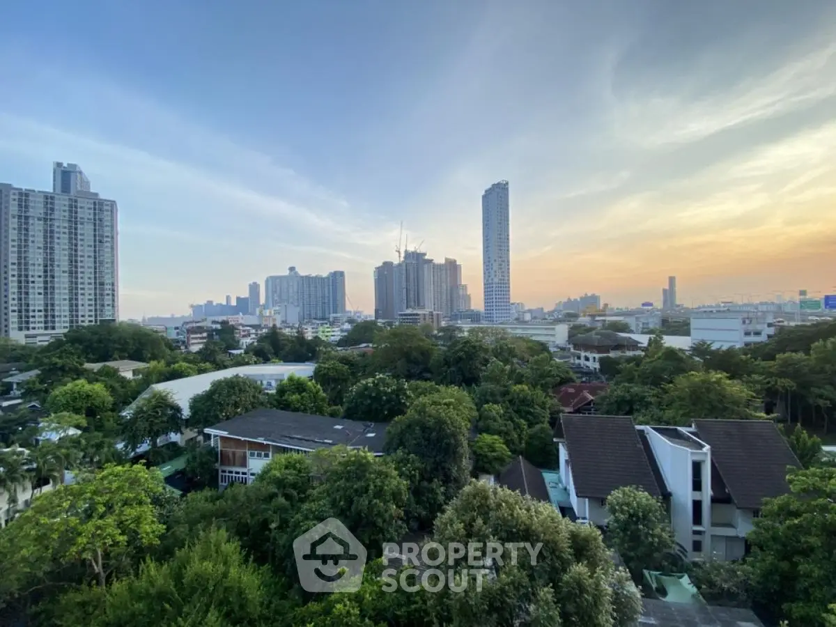 Stunning cityscape view with lush greenery and modern high-rise buildings at sunset.