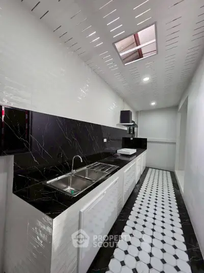 Modern kitchen with sleek black and white design featuring dual sinks and stylish flooring.
