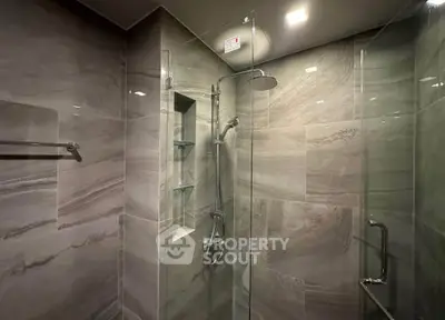 Luxurious modern bathroom with sleek glass shower and elegant tile design.