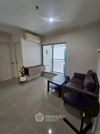 Modern living room with sleek furniture and balcony access, perfect for urban living.