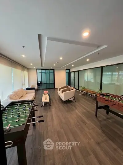 Spacious modern living room with foosball tables and cozy seating area