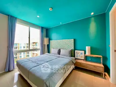Bright and modern bedroom with teal accents and large window view