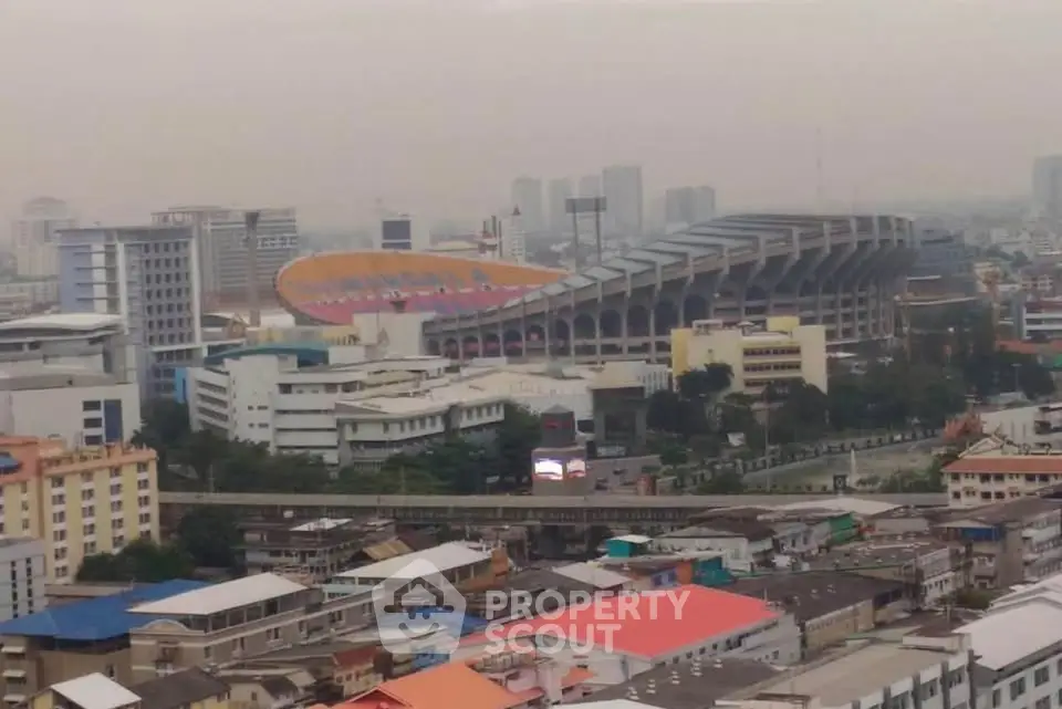 Panoramic cityscape view featuring a large stadium and urban skyline, ideal for real estate investment insights.