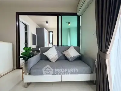 Modern living room with stylish sofa and large window, offering a cozy and inviting atmosphere.