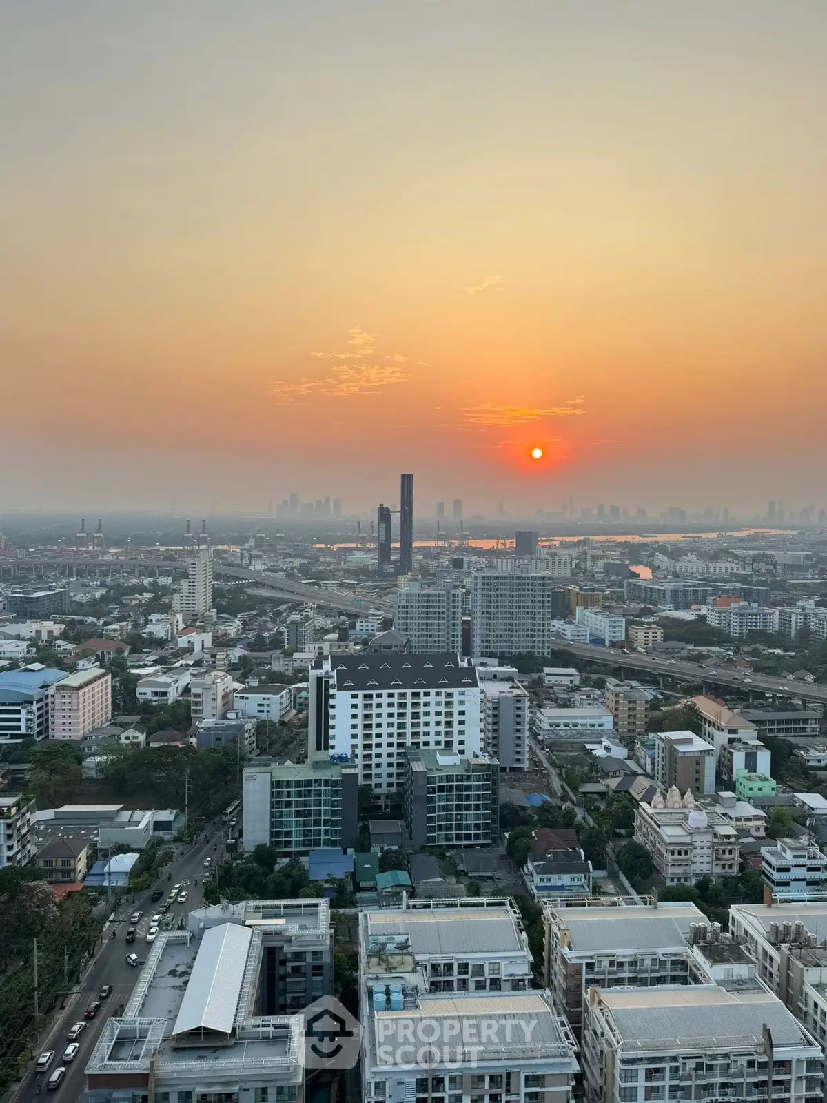Stunning cityscape view at sunset from a high-rise building, showcasing urban skyline and vibrant horizon.