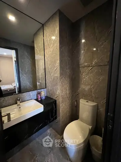 Luxurious modern bathroom with marble walls and sleek fixtures in a high-end property.