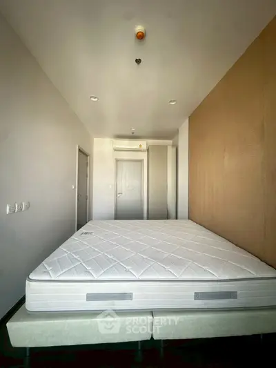 Spacious bedroom with modern design and comfortable mattress in a well-lit apartment.