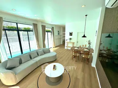 Spacious living room with elegant dining area and large windows for natural light