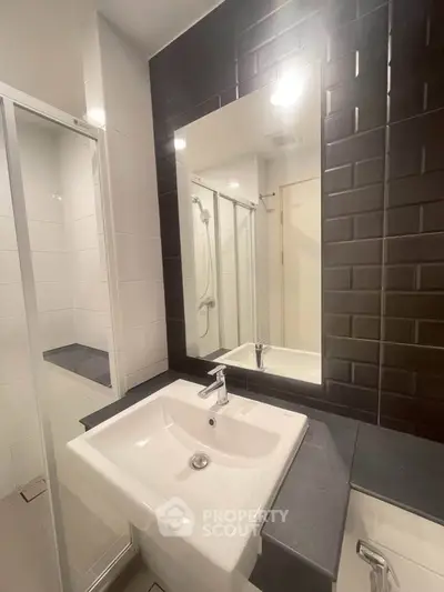 Modern bathroom with sleek black tiles and white fixtures