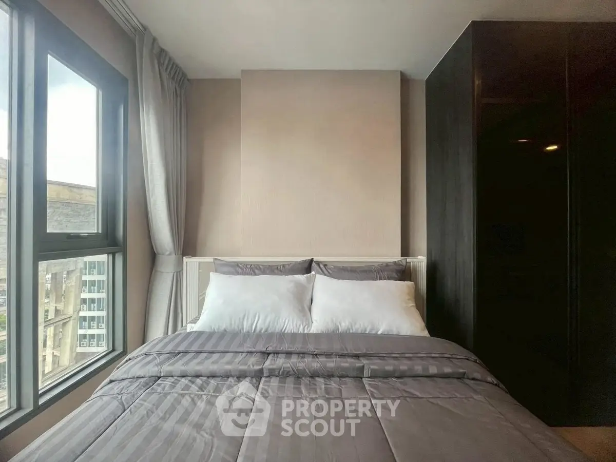 Modern bedroom with large window and stylish decor in urban apartment