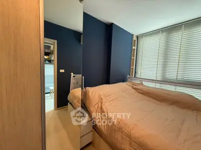 Cozy bedroom with modern decor and large window blinds, featuring a comfortable bed and sleek wooden flooring.