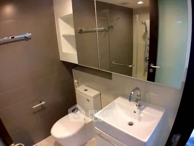 Modern bathroom with sleek fixtures and large mirror in contemporary apartment.