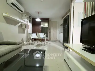 Modern living room with sleek furniture and open kitchen layout in a stylish apartment.
