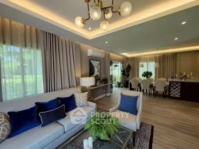 Luxurious open-plan living and dining area with elegant decor and modern lighting.