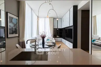 Luxurious modern living room with open kitchen and elegant dining area, featuring sleek design and ample natural light.