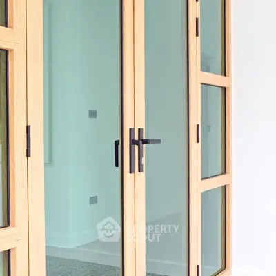 Elegant wooden framed glass doors leading to a modern interior space