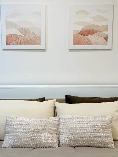 Stylish bedroom with modern art and cozy pillows for a serene ambiance.