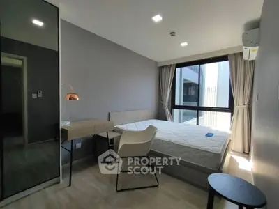 Modern bedroom with large window and stylish furniture in a contemporary apartment.