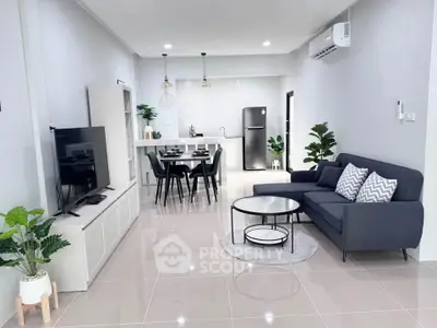 Modern open-plan living room with sleek kitchen, stylish furniture, and contemporary decor.