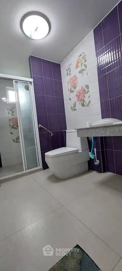 Modern bathroom with purple tiles and floral accents