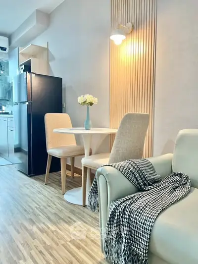 Modern living room with cozy seating and dining area, featuring stylish decor and natural lighting.