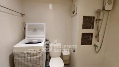 Compact bathroom with washing machine and shower in modern apartment