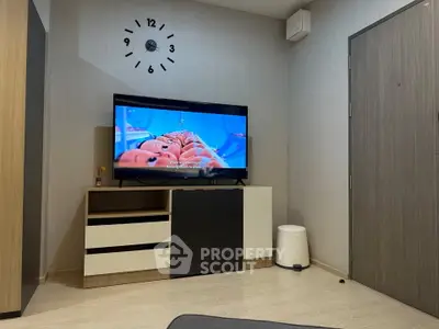 Modern living room with stylish TV setup and wall clock, perfect for cozy evenings.