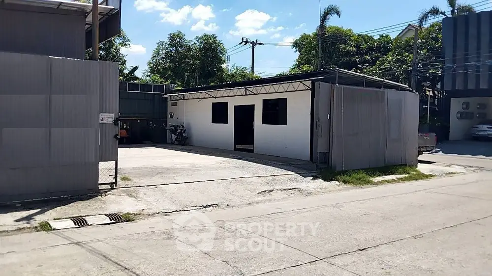 Industrial warehouse with metal siding and spacious outdoor area in urban setting.