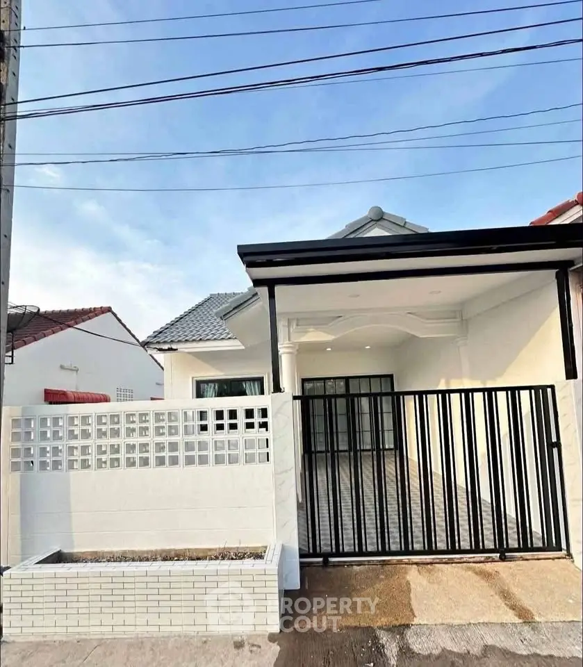Charming single-story home with gated entrance and modern exterior design.