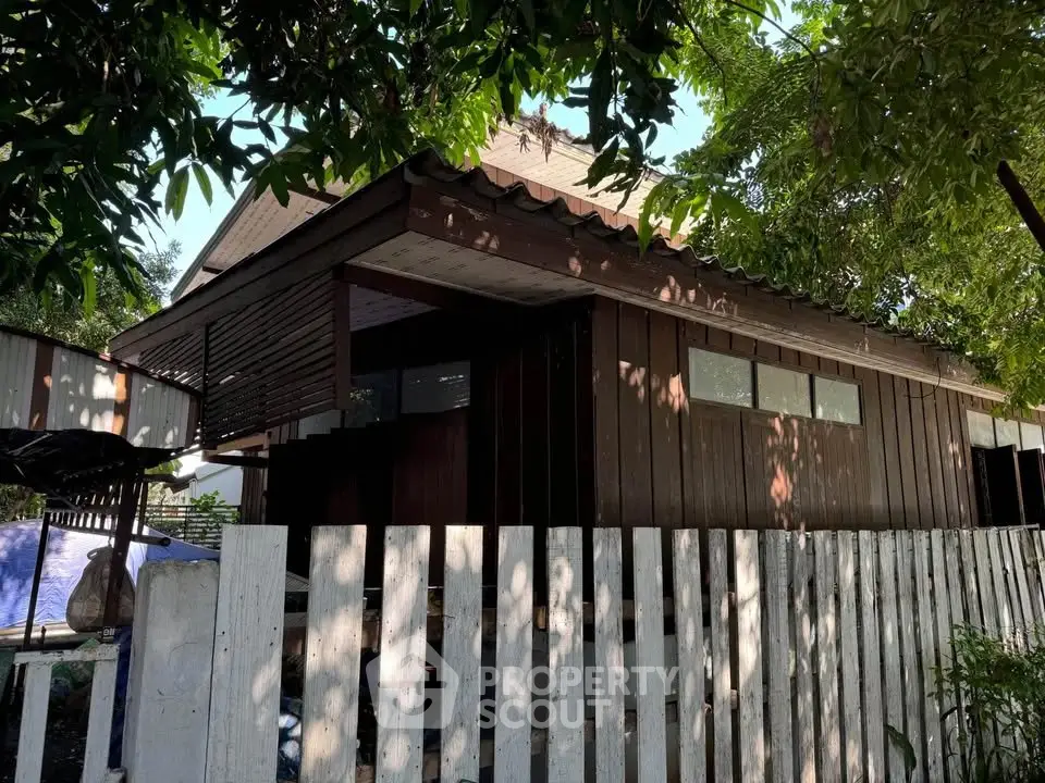 Charming rustic wooden house with lush greenery and white picket fence