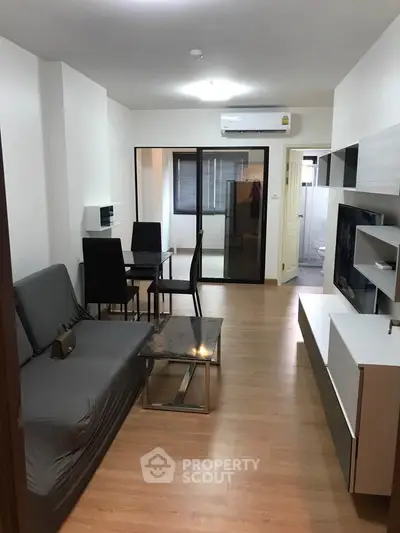 Modern living room with sleek furniture and open layout, featuring a cozy dining area and stylish decor.