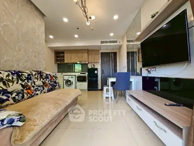 Modern living room with open kitchen, featuring sleek appliances and stylish decor.