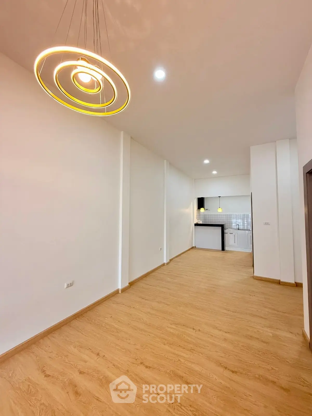 Spacious modern living room with stylish lighting and open kitchen layout