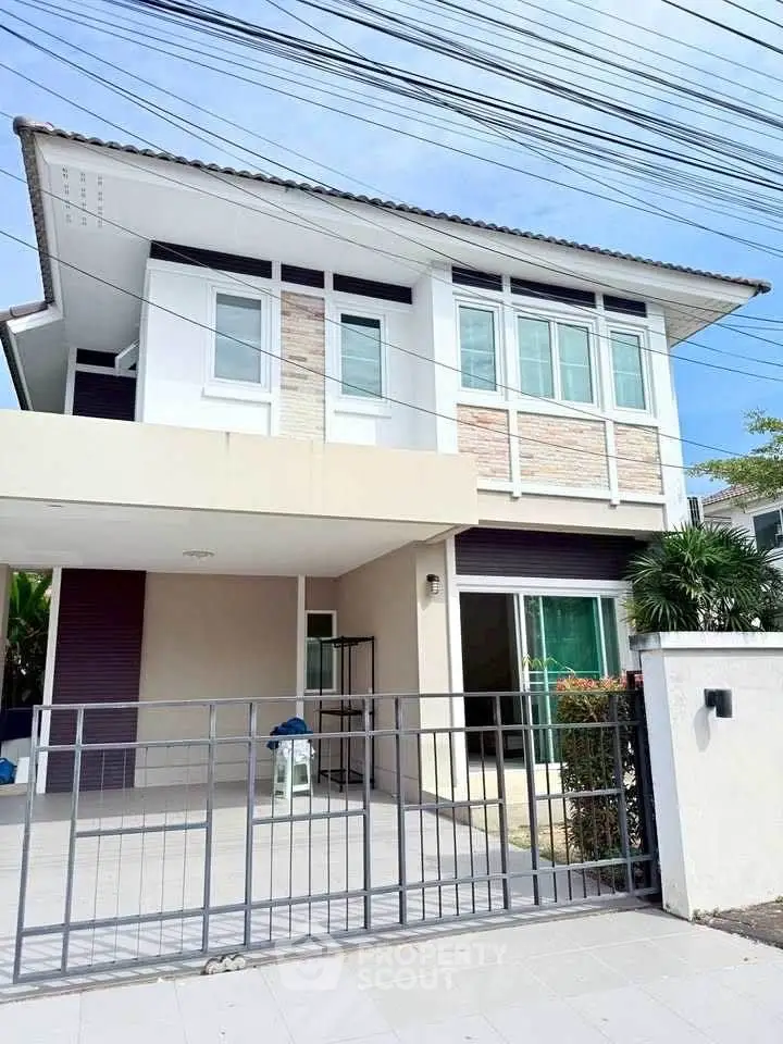 Modern two-story house with gated entrance and large windows