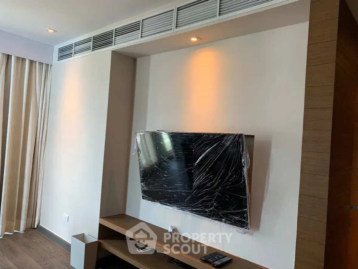 Modern living room with wall-mounted TV and sleek wooden furniture, perfect for contemporary living.