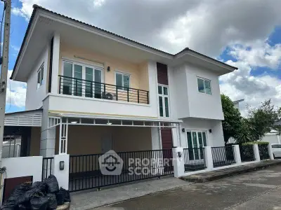Modern two-story house with balcony and garage in a suburban neighborhood.