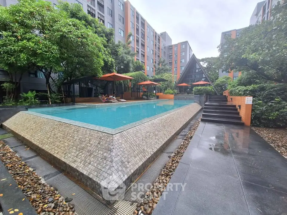 Luxurious apartment complex with stunning pool and lush greenery