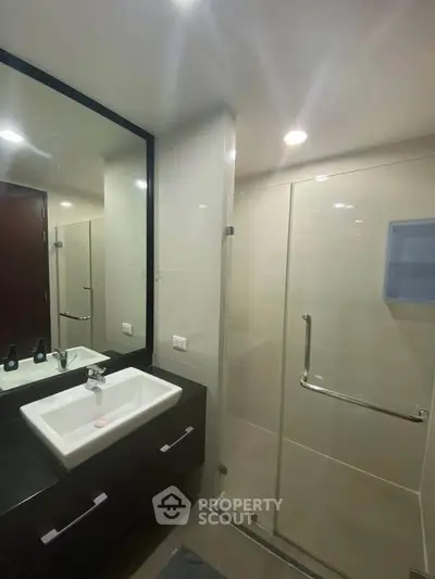 Modern bathroom with sleek design featuring a glass shower and stylish vanity.