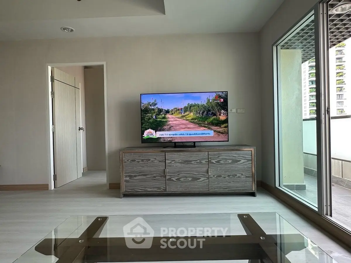 Modern living room with TV and balcony access in a stylish apartment.