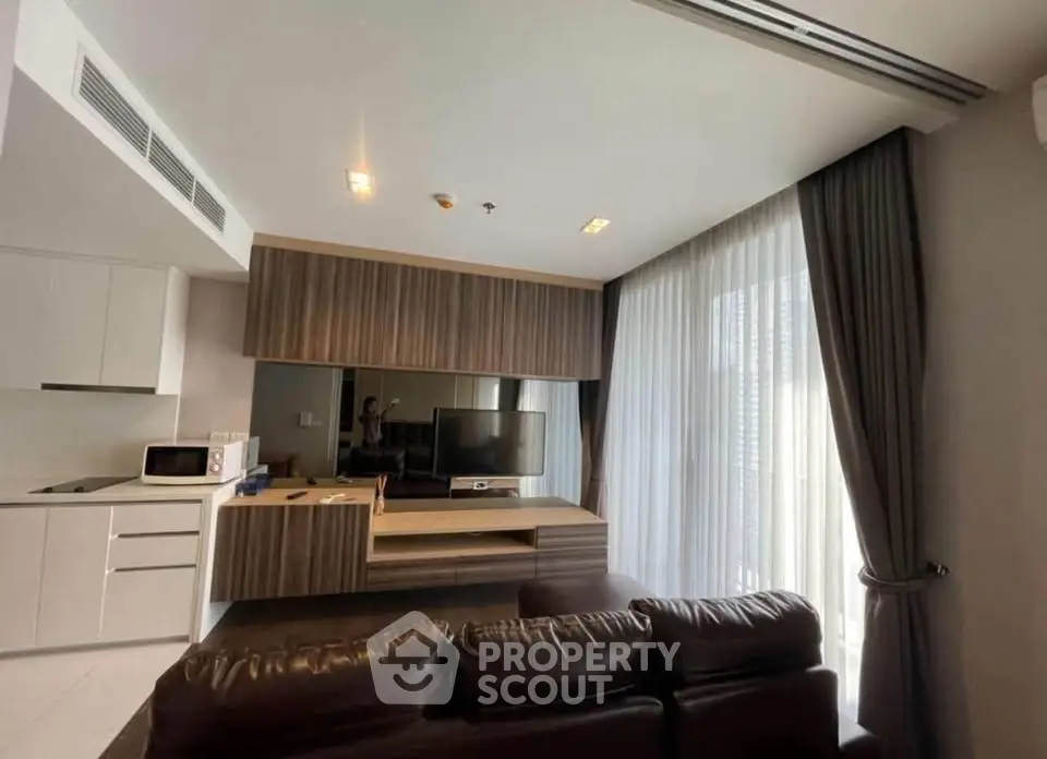 Modern living room with sleek furniture and large windows in a stylish apartment.