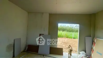 Unfinished interior room with open doorway to garden view